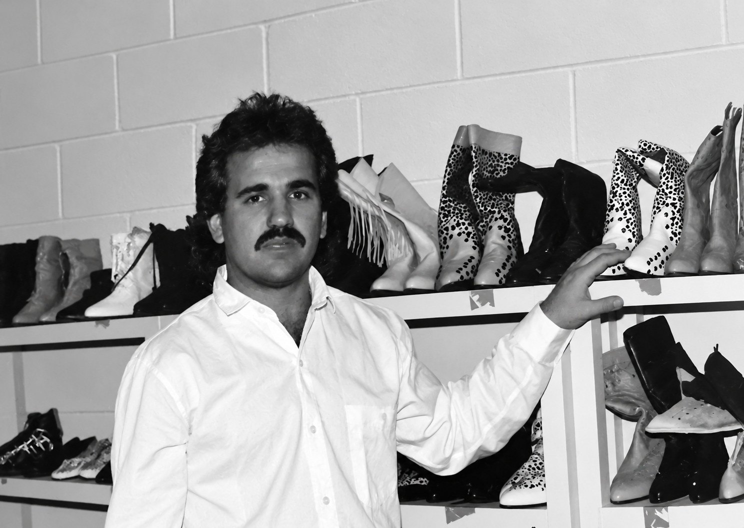 Jay Adoni in the 1980s beside shelves of boots, from the book The Dynamos